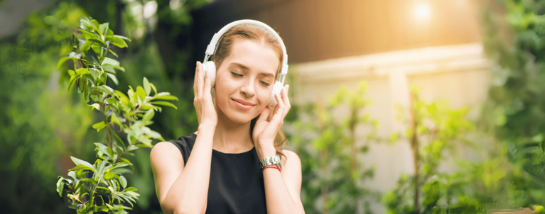 Frau hört mit Kopfhörern Musik über Spotify