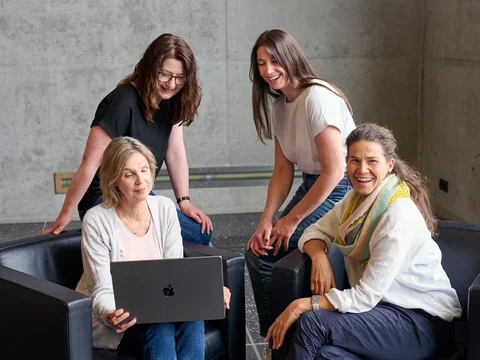 Das Addressable-TV-Team berät sich über TV-Werbung an einem Bildschirm