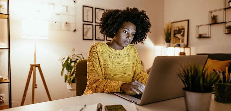 SEO Expertin sitzt vor einem Laptop und recherchiert KeyWords