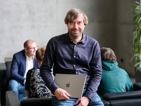 Performance-Marketing-Experte Christian Tretter mit dem SEA-Team im Hintergrund