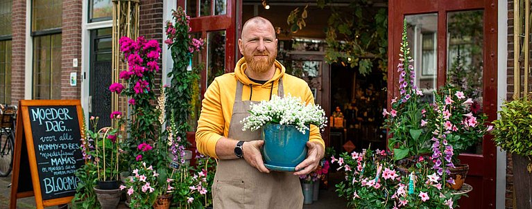 Mann hält Blumentopf in der Hand