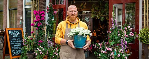 Mann hält Blumentopf in der Hand