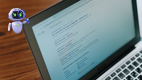 Kleiner KI-Roboter mit Lupe neben einem Laptop, auf dessen Bildschirm Google-Suchergebnisse zu sehen sind. Symbolbild für KI-gestützte Google-Suche.