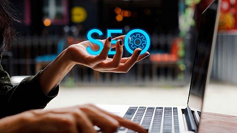 SEO grafisch auf einer Hand geschrieben