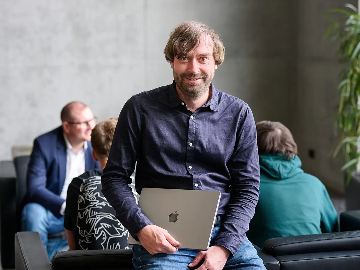 Performance-Marketing-Experte Christian Tretter mit dem SEA-Team im Hintergrund