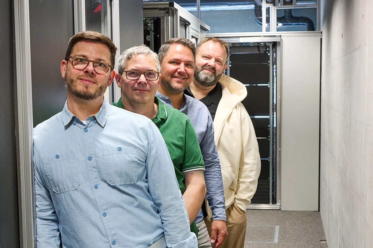 Das Team der iWelt steht hintereinander im Serverraum