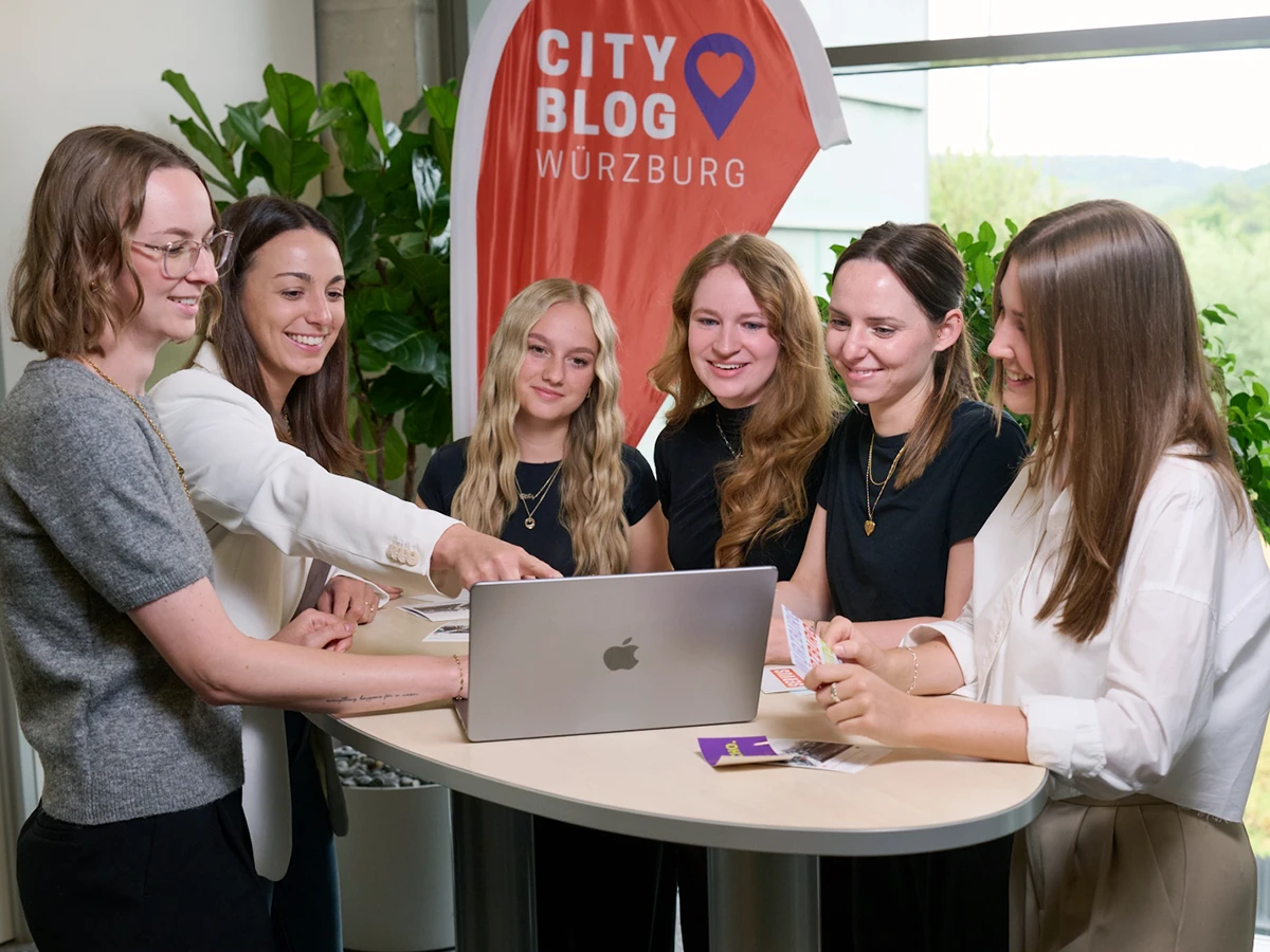 Das Team des City Blogs berät sich über lokale Werbung vor dem Laptop