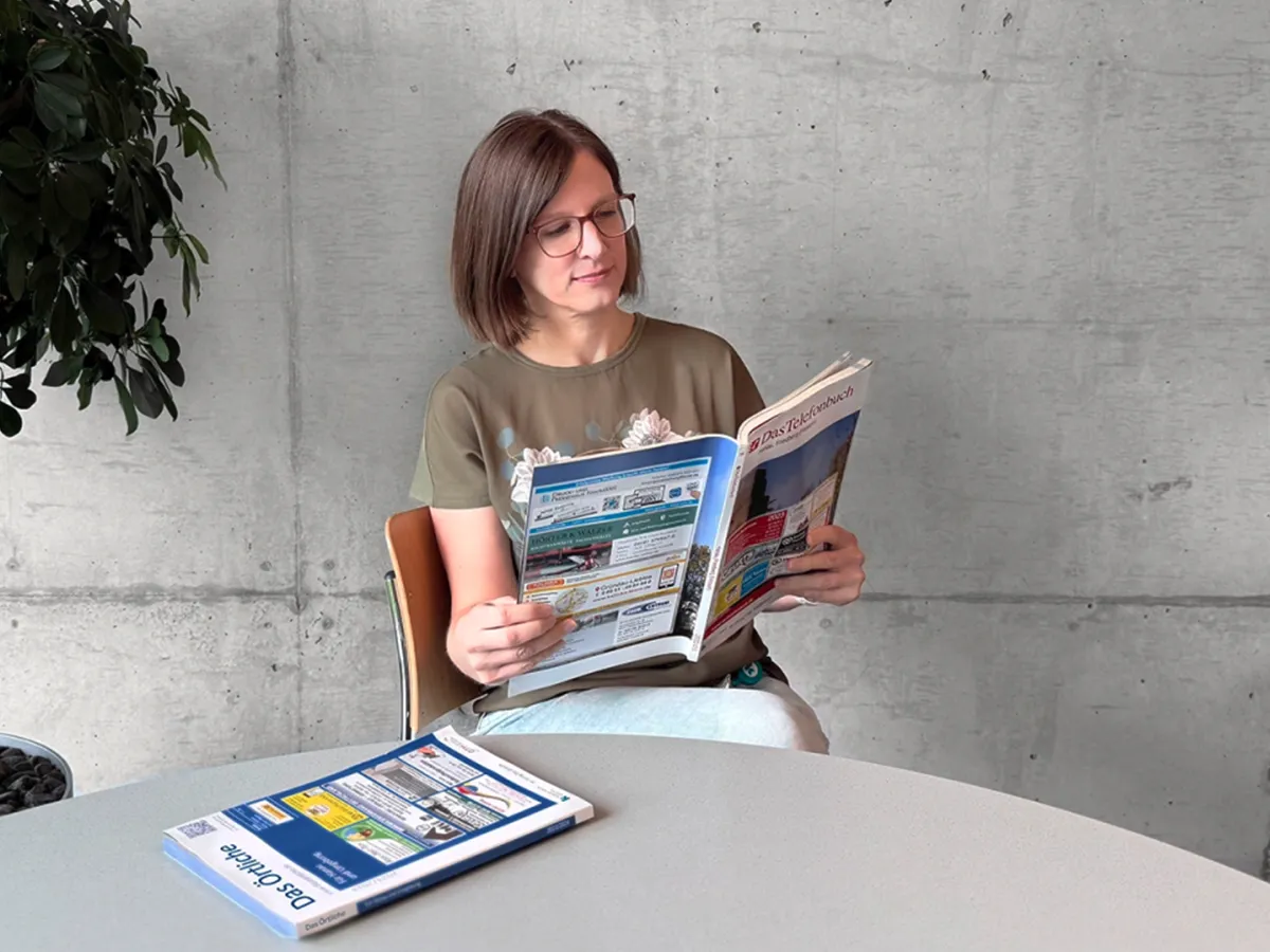 Frau liest das bestellte Telefonbuch