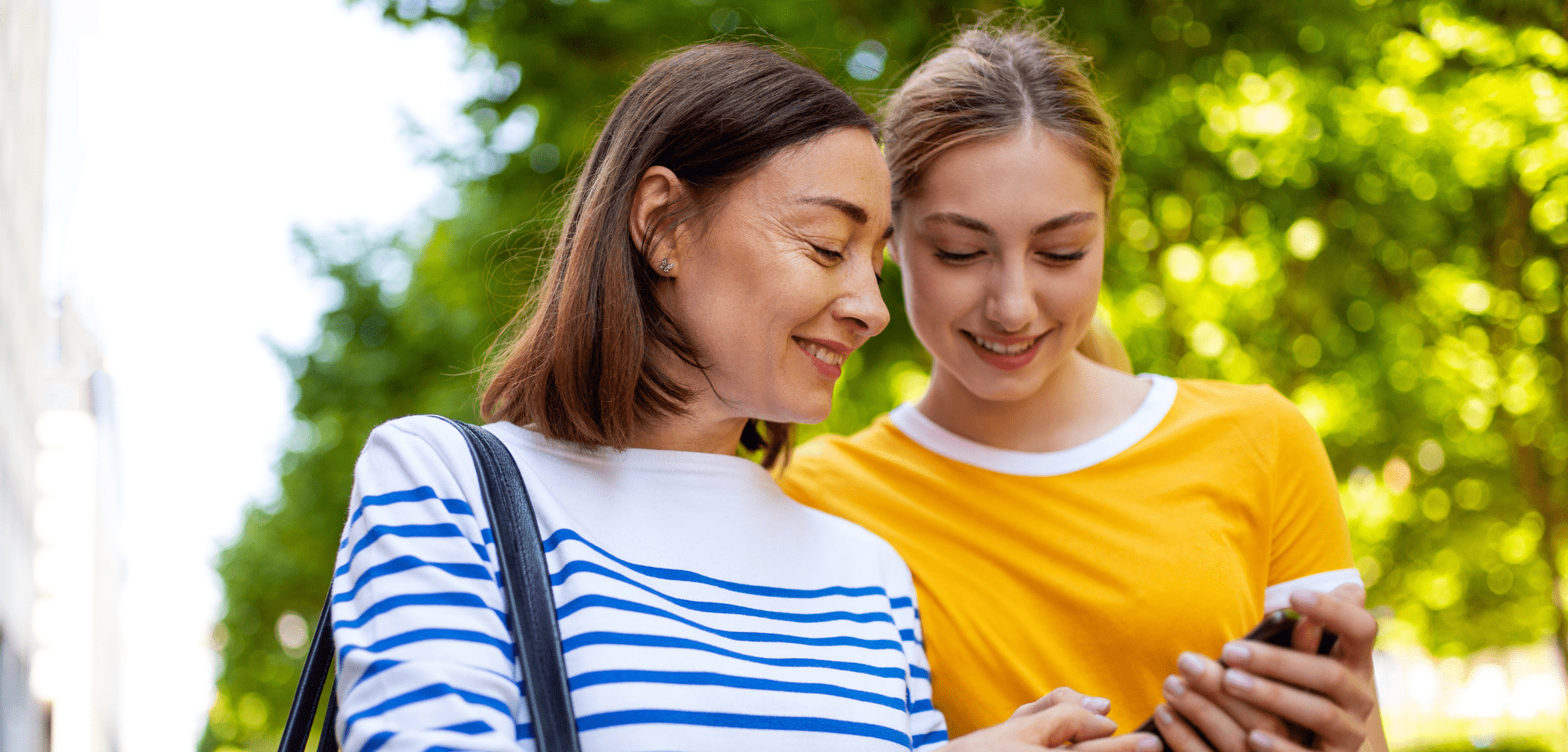 Mutter und Tochter schauen gemeinsam auf ein Smartphone